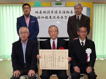 賞状を持つ野稲理事長