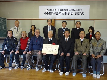 賞状を手にする小林代表と関係者との集合写真