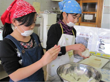 おむすび教室 ご飯をラップにくるんで丁寧ににぎる児童