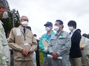 飯舘村の農地所染対策実証事業の現場で門馬副村長と意見交換する岩本農林水産副大臣