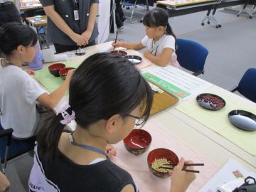 豆つかみゲームを楽しむこどもたち