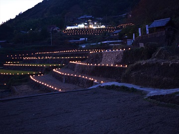 田んぼの畔に灯篭が置かれた幻想的た景色