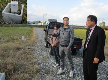 自動給水設備が導入されたほ場で徳永さんから説明を受ける田中地方参事官