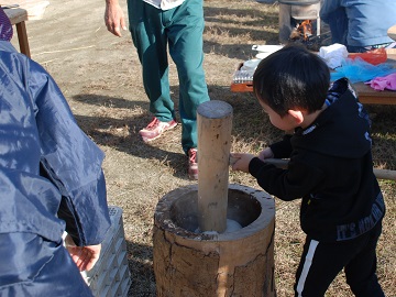 昔ながらの杵と臼で餅つきを行う子供たち