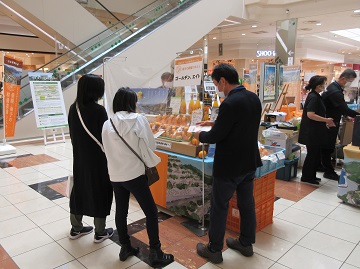 マルシェ出展者から商品の説明を受ける様子