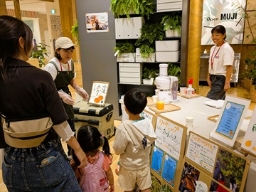 みかんジュース作りを体験する親子