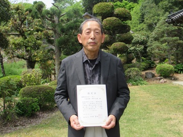 認定証を手交された代表理事の野崎幸雄氏
