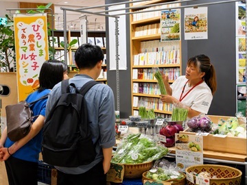 野菜の説明を行う農業女子と来場者