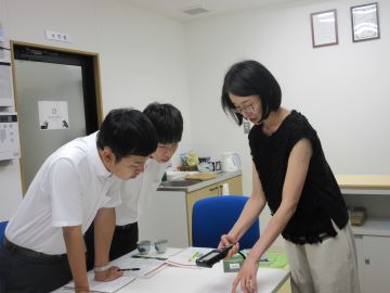 操作説明を行う職員と説明を聞く学生