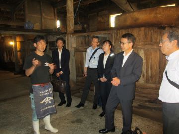 山本社長から蔵の中の木桶の前で説明をを受ける