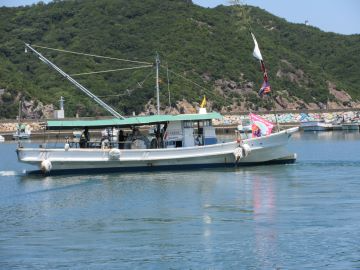 沖合での放流に向け出港する漁船