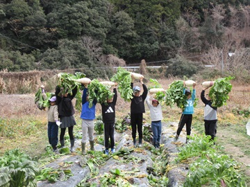 収穫しただいこんを掲げる子供たち