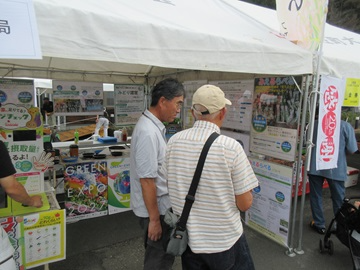 来場者に「見える化」について説明