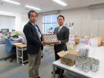 事務局長(右)に備蓄食料を提供