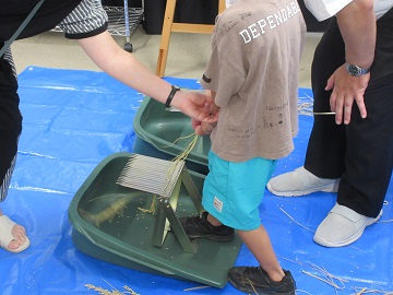 脱穀体験をする参加者
