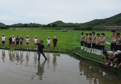 田植えの説明をする高校生