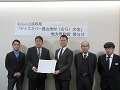 選定証を持つ大西代表取締役(中央左)