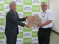 大木事務局長（左）へ引き渡す菅井副地方参事官