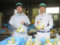 「みえるらべる」を付けた梨を手にする生徒