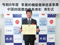 表彰状を手にする的事務局長