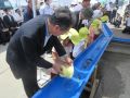 稚魚を放流する園児と朝倉地方参事官