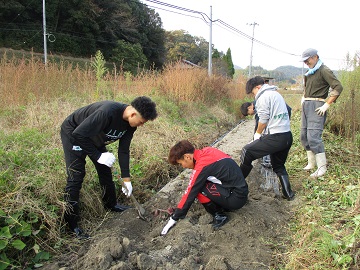 斎藤氏に芋ほりのコツを聞き作業をする学生