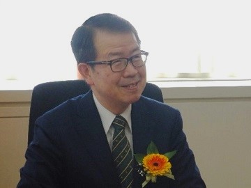 コサージュを胸にさす中国四国農政局長