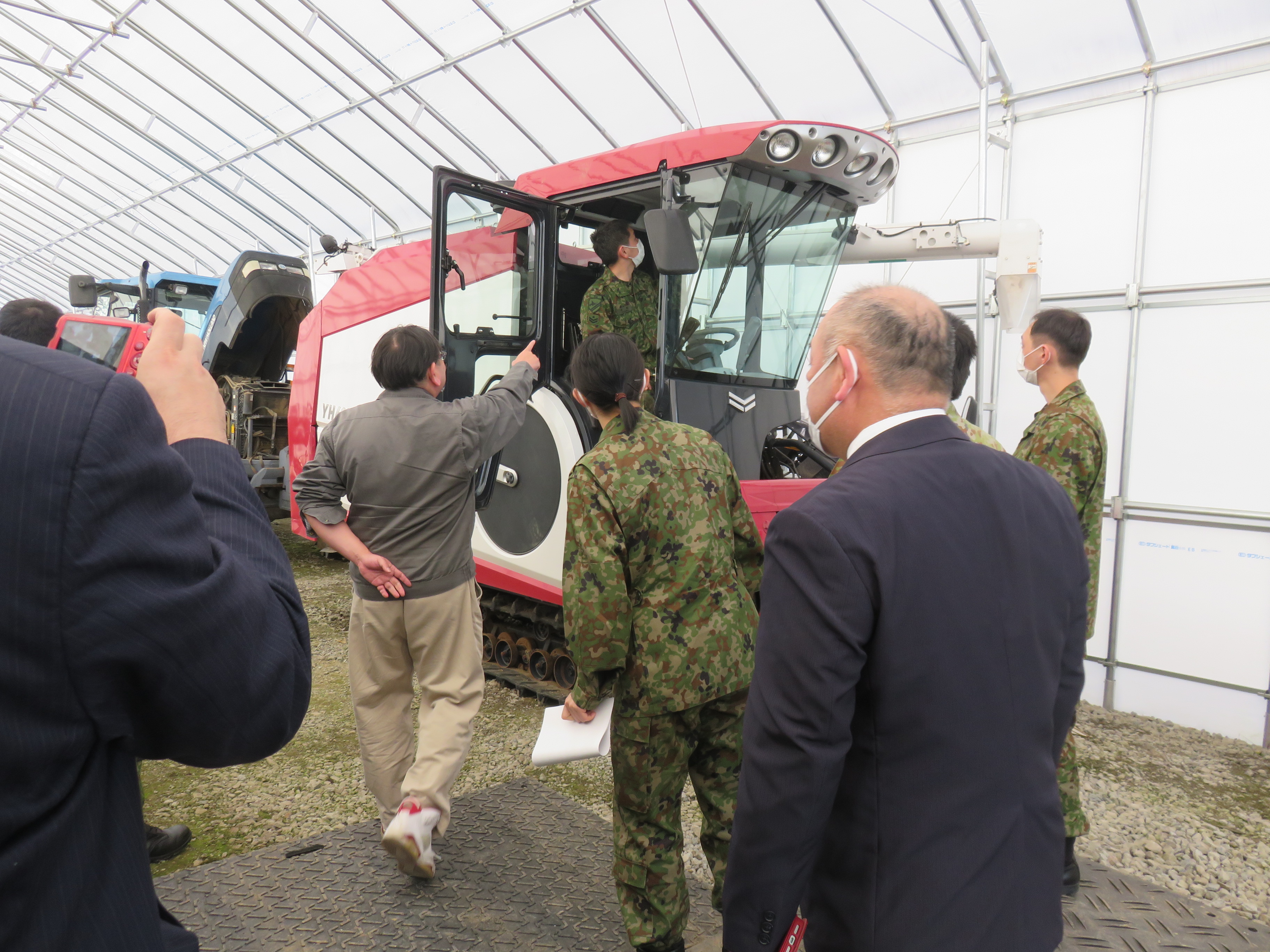 【コンバインに乗車する自衛隊員】