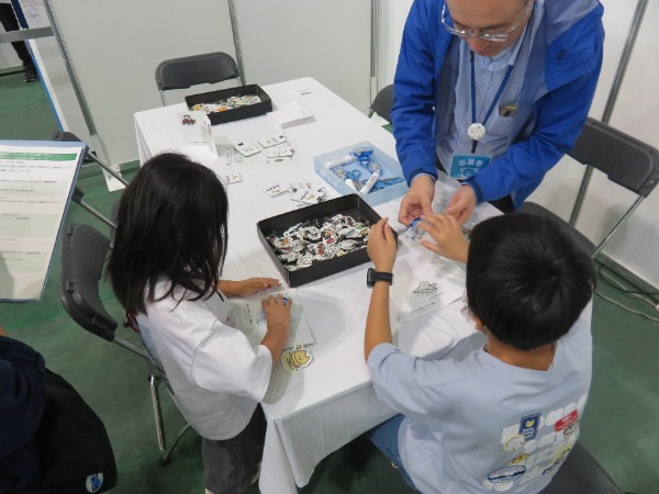 カードの作り方を教える職員