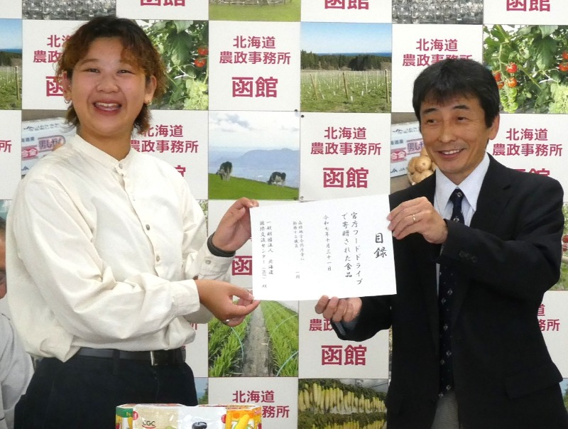 目録の贈呈（北海道国際交流センター（左）、函館地域拠点地方参事官（右））