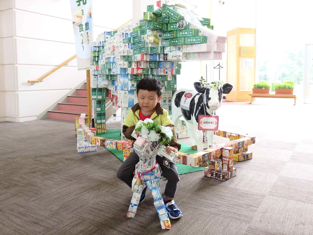 子牛に跨りジャンボ牛と記念撮影