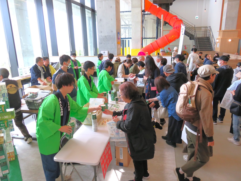 試飲の牛乳を受け取る来場者