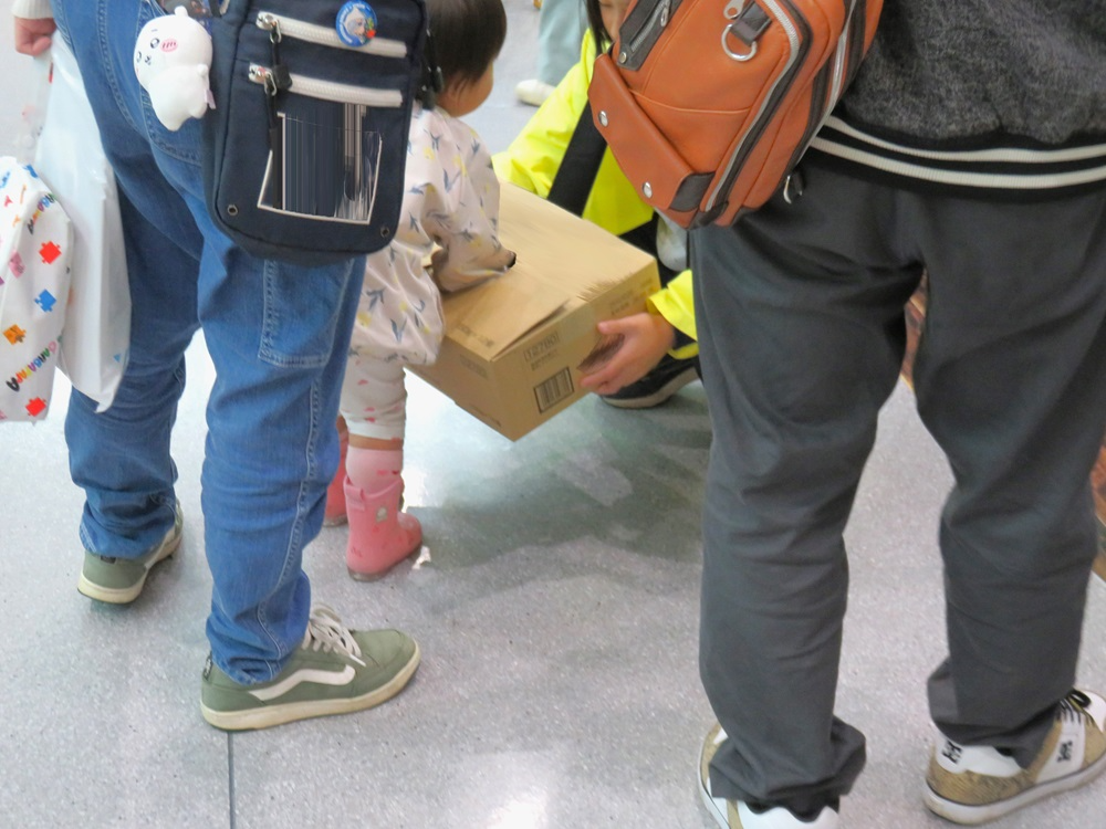 部員手作りのしおりを選ぶ子供