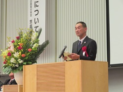 北陸農政局長祝辞を代読する田口地方参事官（写真左）と授与後の記念撮影