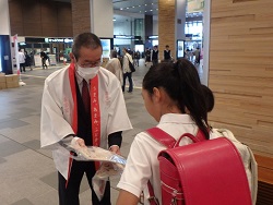 パックご飯を配布する漆間地方参事官