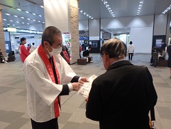 パックご飯を配布する漆間地方参事官