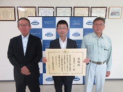 記念写真(左から)漆間地方参事官、花畑代表取締役社長、 舟見取締役