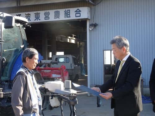 農事組合法人江波東営農組合廻淵組合長（写真左）へ授与の様子