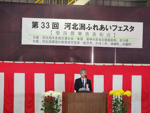 表彰式で祝辞を述べる本田局次長