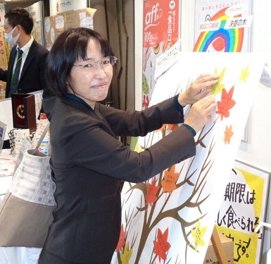 北陸農政局ブースで「決意の木」に食品ロス削減の決意を記した葉を貼る河合局次長