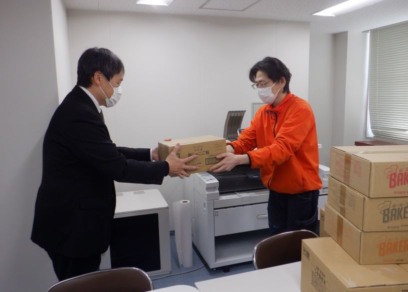 フードバンクに食品を引き渡す水間所長