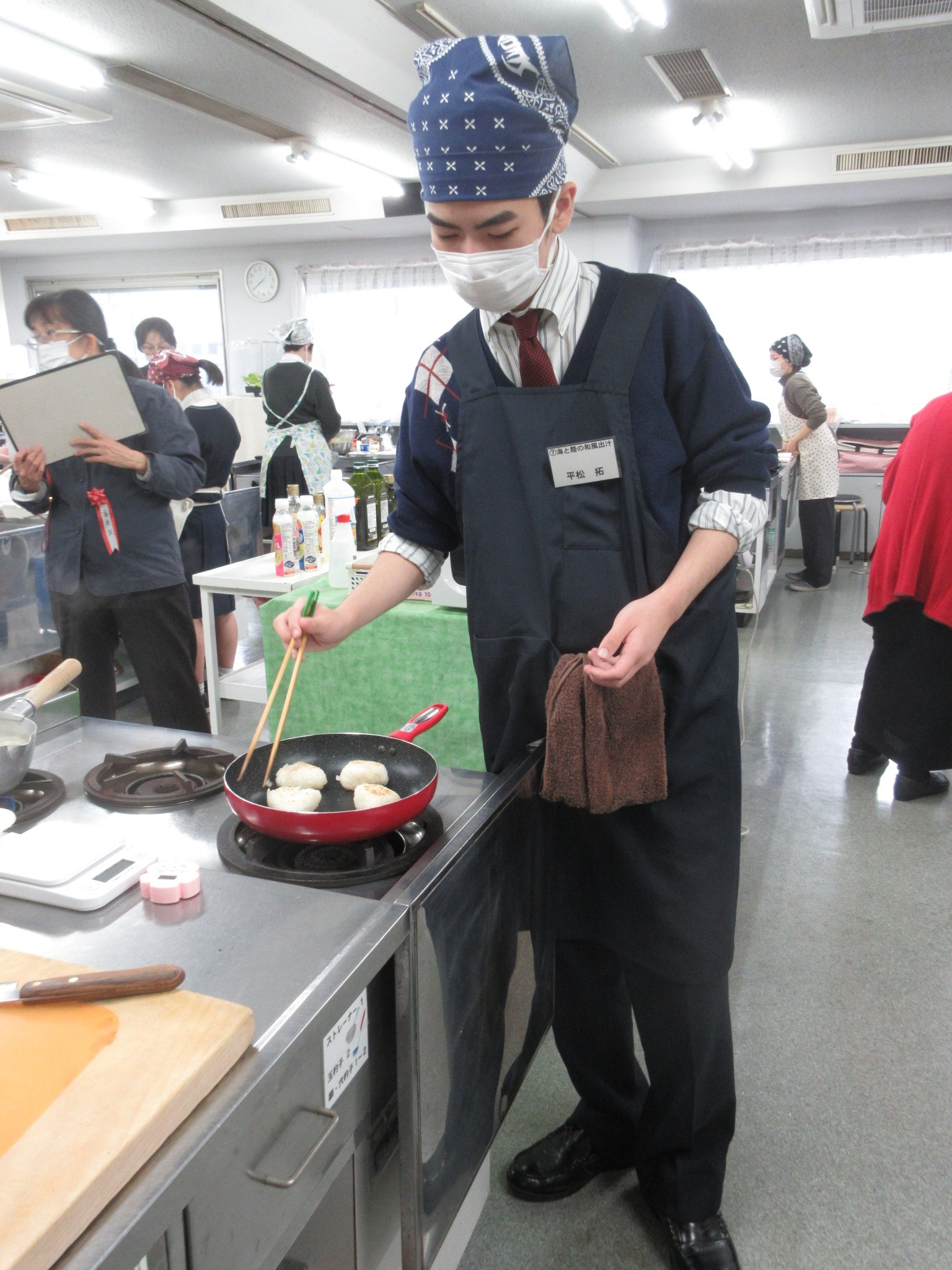 丁寧におにぎりを焼く参加者