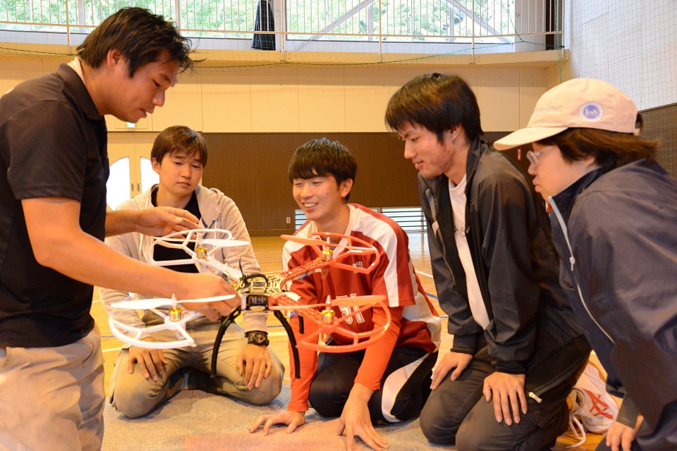 学生がドローンの説明を受けている