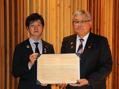 協定締結企業と写真撮影を行う鈴木農林水産大臣（左）