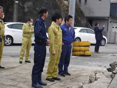 小木港の被害状況について説明を受ける鈴木農林水産副大臣（中央）