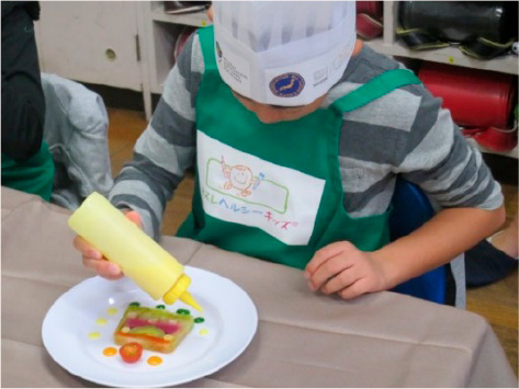 子どもたちが自らソースで飾り付けをする体験授業