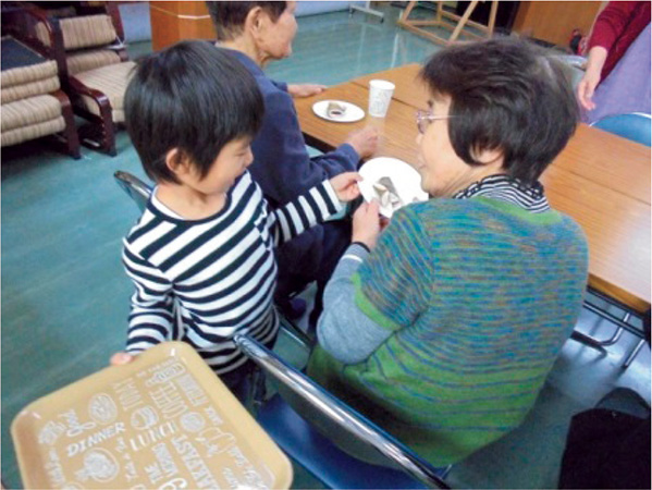 子供達が作ったお茶とお菓子を配る様子
