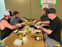外国人４人が机を囲んでおにぎりを食べている様子