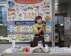 エプロンを来て調理方法について教えている女性の様子