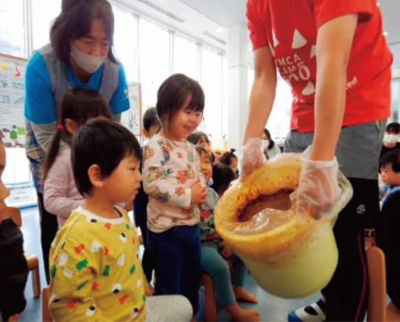 調理室前で食材の説明を受ける子供たち